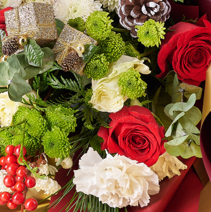 With a mix of white and red roses adorned with gold holiday-themed ornaments and wrapped in a festive bow, this bouquet is a wonderful way to wish someone a Merry Christmas.