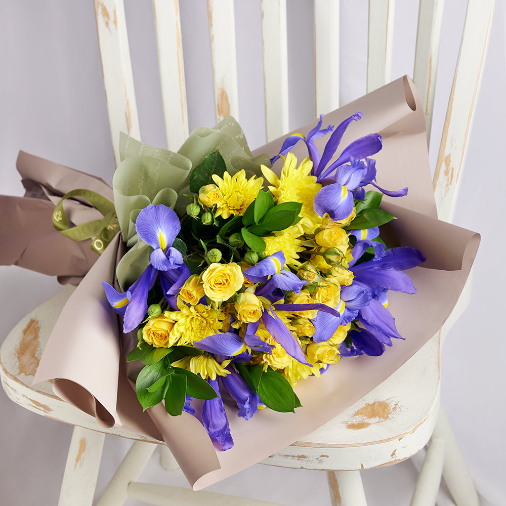 Luminous Lavender Iris Bouquet harmonizes the vibrant yellow of the sun with the soothing lavender tones of irises, creating a versatile flower gift suitable for any occasion. New York Blooms